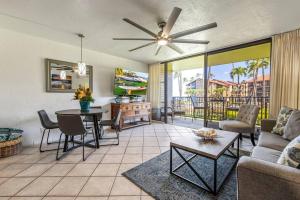 a living room with a ceiling fan and a table at Papakea E206- Updated Papakea oceanview condo, all the amenities in Kahana