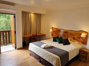sypialnia z dużym łóżkiem i balkonem w obiekcie Hotel Schneider w mieście Treze Tílias