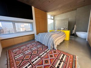 a bedroom with a bed and a rug on the floor at Villa by the lake Elliðavatn - Birta Rentals in Reykjavík