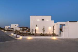 a white building with lights on the side of a street at Seafish Villa, 2 Luxury Villas at Lachania Beach in Lachania