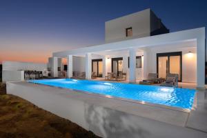 a villa with a swimming pool at night at Seafish Villa, 2 Luxury Villas at Lachania Beach in Lachania