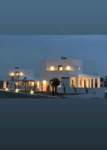 a large white building at night with lights at Seafish Villa, 2 Luxury Villas at Lachania Beach in Lachania