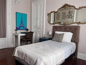 - une chambre avec un lit avec un miroir et un bureau dans l'établissement La Casa de Lola BA, à Buenos Aires