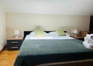 a bedroom with a large bed with green sheets and pillows at Studio Apartment in Catania