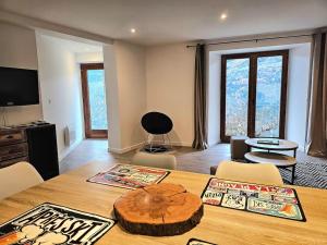 a room with a wooden table with chairs and a tableablish at Appartement de 80m² plein sud entièrement rénové in Aime La Plagne