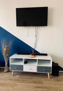 una cómoda blanca con una TV encima en Cocoon citadin : Appartement 2 pièces au coeur d'Evry, en Évry-les-Châteaux