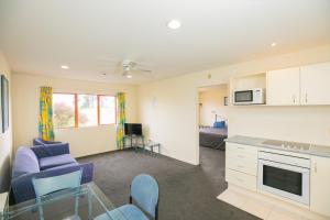 a room with a kitchen and a living room at Albany Executive Motor Inn Limited in Auckland
