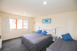 a bedroom with two beds and a window at Albany Executive Motor Inn Limited in Auckland