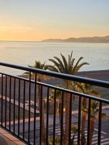 a balcony with a view of the beach and palm trees at APARTAMENTO EN PRIMERA LÍNEA DE PLAYA in Salobreña