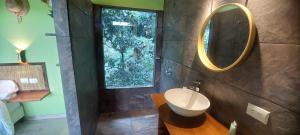 ein Bad mit einem Waschbecken und einem Wandspiegel in der Unterkunft Casita Maripier Colón 