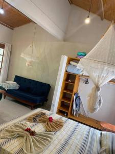 a bedroom with two bunk beds and a blue couch at Loft da Árvore nas Falésias em Cumuruxatiba in Prado