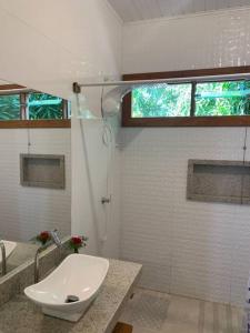 a white bathroom with a sink and a shower at Loft da Árvore nas Falésias em Cumuruxatiba in Prado