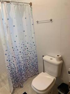 een badkamer met een toilet en een douchegordijn bij Loft da Árvore nas Falésias em Cumuruxatiba in Prado