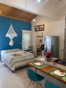 a bedroom with a bed and a table with chairs at Loft da Árvore nas Falésias em Cumuruxatiba in Prado
