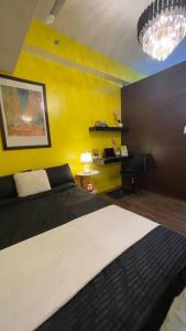 a bedroom with a bed and a yellow wall at Luxurious stay at Air Residences in Manila