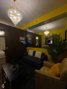 a living room with a couch and a chandelier at Luxurious stay at Air Residences in Manila
