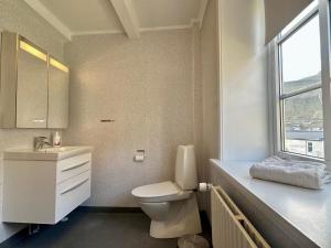 uma casa de banho com um WC, um lavatório e uma janela em House in Fuglafjørður em Fuglafjørður