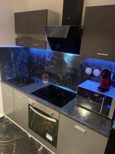 a kitchen with a black counter top with a sink at Appartement 3 pièces en face la gare de creil in Creil +2 photos