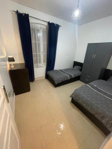 a bedroom with two beds and a window at Appartement 3 pièces en face la gare de creil in Creil