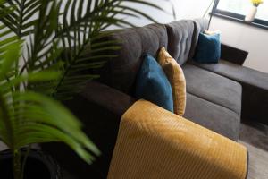 ein Wohnzimmer mit einem Sofa und blauen Kissen in der Unterkunft 'Just like home' Apartment - with Private Parking Place in Galaţi