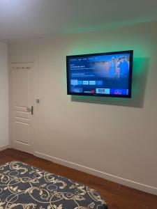 una TV a schermo piatto appesa a un muro bianco di Appartement 3 pièces 60M2 en face la gare de creil a Creil