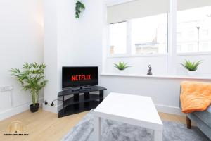 uma sala de estar com uma televisão e um sofá em Hephaestus Apartment - The Craftsman of Town em Southampton