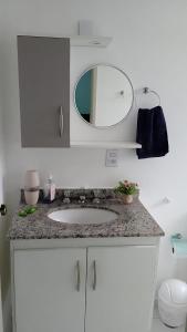 a bathroom counter with a sink and a mirror at Apartamento Completo A25 Flat Centro in Mogi das Cruzes