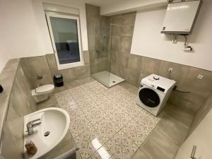 a bathroom with a sink and a washing machine at City Apartment - 9 Bedrooms - 22 Beds - WiFi - Kitchen in Paderborn