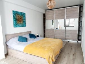 1 dormitorio con 1 cama grande con almohadas azules en 'Just like home' Apartment - with Private Parking Place en Galaţi