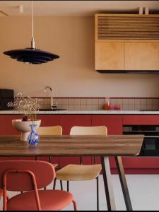 a kitchen with a wooden table and chairs at Domki Płyniewoda - całoroczne domy PREMIUM, klimatyzacja, kominek, blisko morza in Dziwnów +35 photos