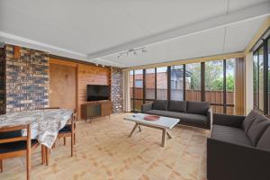 a living room with a couch and a table at Ocean Breeze Vincentia by Book Jervis Bay in Vincentia