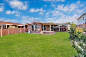 a house with a lawn in front of it at Ocean Breeze Vincentia by Book Jervis Bay in Vincentia