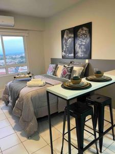 a bedroom with a bed and a table with two stools at Apartamento 1445 Encantador in Ribeirão Preto