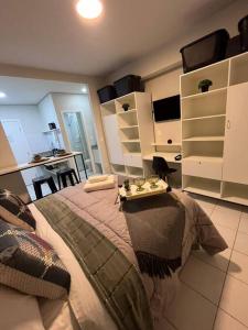 a bedroom with a large bed with a table on it at Apartamento 1445 Encantador in Ribeirão Preto