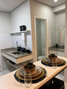 a kitchen with a table with plates and glasses on it at Apartamento 1445 Encantador in Ribeirão Preto +27 photos