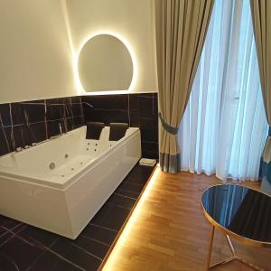 een badkamer met een bad en een ronde spiegel bij La Lepre Bovio in Napels