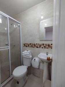 y baño con aseo, lavabo y ducha. en Hotel Orquídea Real en Valledupar