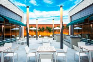 a patio with tables and white chairs and umbrellas at Element Boston Seaport District in Boston