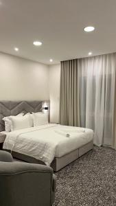 1 dormitorio con 1 cama grande y 1 sofá en جادا للشقق المخدومة Jada en Al Khobar