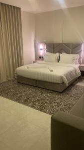1 dormitorio con 1 cama grande con almohadas blancas en جادا للشقق المخدومة Jada en Al Khobar