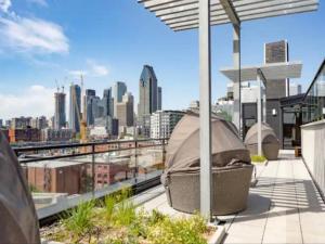a rooftop patio with a view of a city at Appartement de luxe avec piscine in Montréal