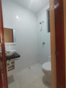 Baño blanco con aseo y lavamanos en Apartments, en Chiclayo