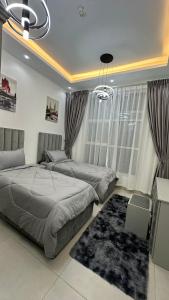 a bedroom with two beds and a rug at Luxury 2 bedroom new brand in Ajman 