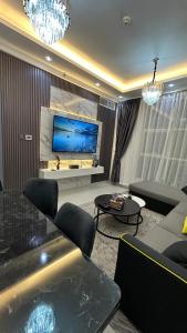 a living room with a couch and a tv at Luxury 2 bedroom new brand in Ajman 