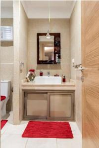 a bathroom with a sink and a red rug at Appartement de rêve à Marrakech in Marrakech