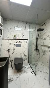 a bathroom with a toilet and a glass shower at Luxury 2 bedroom new brand in Ajman 