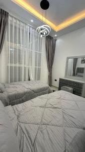 a bedroom with two beds and a large window at Luxury 2 bedroom new brand in Ajman 