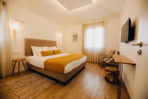 a hotel room with a bed and a television at Casas do Calhau Miúdo - Seixal in Seixal