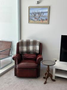 a living room with a chair and a table at SEABREEZE at Victor Harbor in Victor Harbor