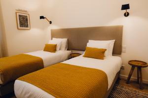 two beds sitting next to each other in a room at Casas do Calhau Miúdo - Seixal in Seixal